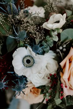 an arrangement of flowers and greenery in a vase