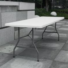 a white table sitting on top of a sidewalk