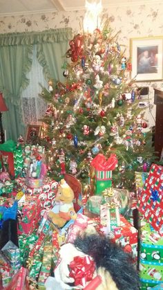 a christmas tree with presents under it in a living room