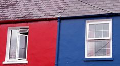 two red and one blue houses with windows