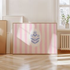 a pink and white striped box sitting on top of a hard wood floor next to a radiator