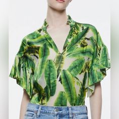 A Ruffle-Trim Stand Collar Tops This Silk-Rich Blouse Covered In A Tropical Palm Print And Framed By Fluttery Elbow-Length Sleeves. Stand Collar Split Neck Elbow-Length Sleeves 67% Viscose, 33% Silk Green Silk V-neck Top, Summer V-neck Blouse With Tropical Print, Silk V-neck Printed Tops, Silk V-neck Top For Vacation, Summer Silk Printed Tops, Elegant Printed Blouse For Summer, Green Silk Blouse For Summer, Silk Blouse For Vacation, Elegant Printed Tops For Vacation