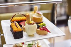 three tiered trays with different types of desserts on top of each other