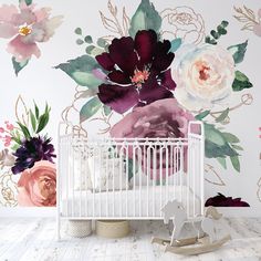 a white crib in front of a floral wall mural