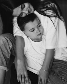 a woman sitting next to a little boy