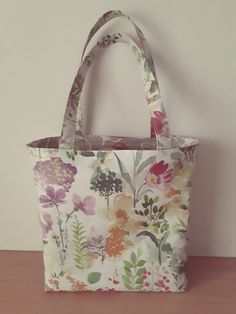 This lovely tote bag gives you a feel of spring with the design of pretty flowers.The bag has been made from top quality cotton-backed soft oilcloth with an extra layer of cotton in between the oilcloth and the lining.The bag is fully lined with a pocket for extra security.The sizes are 16 ins across the top and 12.25ins side seam with a generous boxed base.The lining may vary but always a good match. The handles have been lightly padded. Cheap Purses, Bag Lunch, Sac Lunch, Oil Cloth, Womens Purses, Lunch Bag, Pretty Flowers, Luxury Bags, Handles