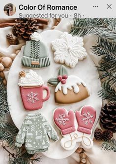 some cookies are sitting on a plate next to pine cones and snowflakes