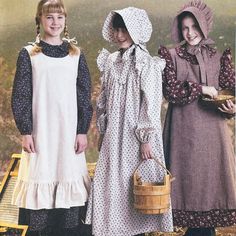 three girls in dresses and bonnets are standing next to each other, one holding a basket