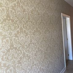 an empty room with a door and wallpaper on the walls is pictured in this image