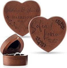 two wooden heart shaped boxes with wedding rings in them and the box is open to show their names