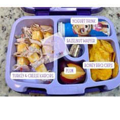 a purple lunch box filled with lots of different types of food and words on it