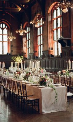 the tables are set up with white linens and candles for an elegant wedding reception