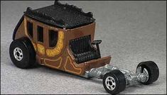 a toy truck with a wooden cab and wheels on the front is sitting on a gray surface