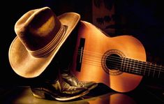 a hat, cowboy boots and an acoustic guitar