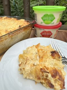 a white plate topped with food next to a container of ice cream and a fork