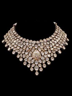 "Mendhika Jadau Polki Set A gold tone chunky Polki Jadau Necklace Set with big Kundan stones. An array of mini polki pieces encircle a jadau kundan pear shape motif with beautiful matching jhumkis/earrings. Can be worn with a statement long necklace for a bridal jpiece. Approximate earrings length is 3.5\". * Check out Manpreet Toor wearing this for a shoot to see the entire look! Tikka and different set of earrings can be added for additional cost. Gold-plated on high-quality brass as base meta