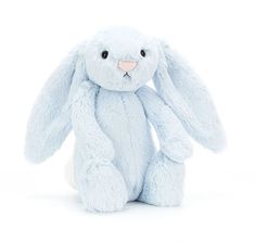 a light blue stuffed bunny rabbit sitting up against a white background with one eye open