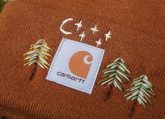 a close up of a hat with trees on it and the words campant written in white