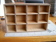 a cardboard shelf sitting on top of a wooden table