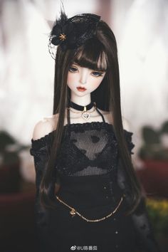 a doll with long hair wearing a black dress