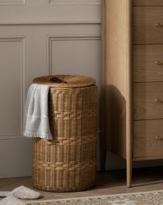 a wicker laundry basket next to a dresser