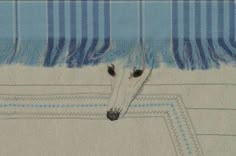 a dog's head is peeking out from behind a blue and white striped blanket