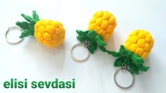 three crocheted corn on the cob keychains are shown in yellow and green