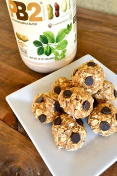 some granola balls are on a plate next to a jar of peanut butter and chocolate chips