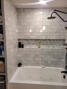 a bathroom with white tile walls and flooring, including a bathtub in the corner