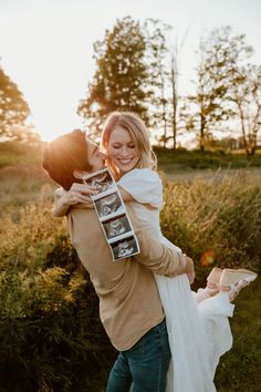 a man and woman hugging each other in the grass