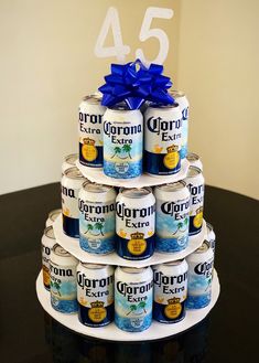 a tiered cake made out of cans with blue ribbon on top and the number 54