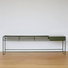 a metal bench sitting on top of a hard wood floor