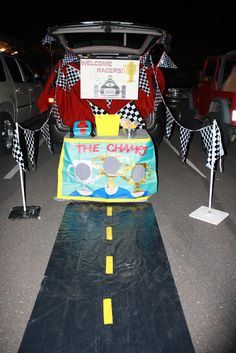 the back end of a car that is decorated with racing flags and race cars on it