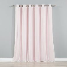 a pink curtain hanging on the side of a gray wall in front of a wooden floor