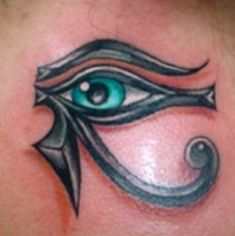 an eye tattoo on the back of a woman's shoulder and chest, with green eyes