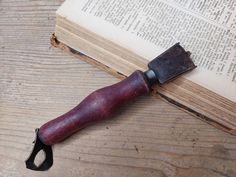 an old book with a knife on top of it