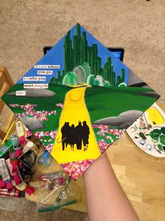 someone is holding up a graduation cap with the image of two horses and cactuses on it