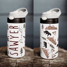 two white and black water bottles sitting on top of a tree stump next to each other