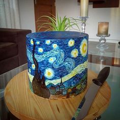 a cake decorated with an image of the starry night is on a table next to a knife