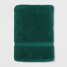 a dark green towel folded on top of a white wall