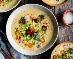 three bowls filled with soup sitting on top of a table next to utensils