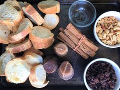 bread, raisins, nuts and other foods are on a baking sheet with a black tray