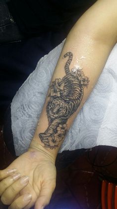 a person with a tiger tattoo on their arm