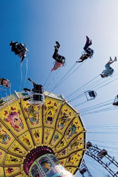 an amusement park ride with lots of people riding on it's ferris wheel and flying through the air