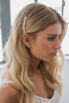 a woman with long blonde hair wearing a white dress and a headband that has pearls on it