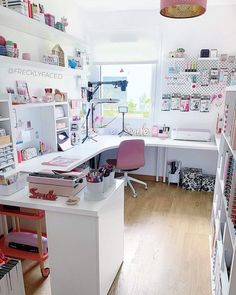 a home office with lots of crafting supplies on the desk and shelving units