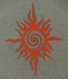 an orange sun with spirals on it in the middle of a gray fabric background