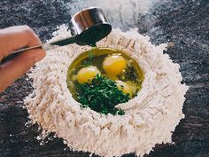 two eggs in a bowl with parsley and seasoning being mixed into the mixture