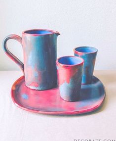 two blue cups and one pink cup on a tray