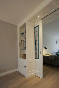 an open door leading to a living room with a couch in the background and a mirror on the wall